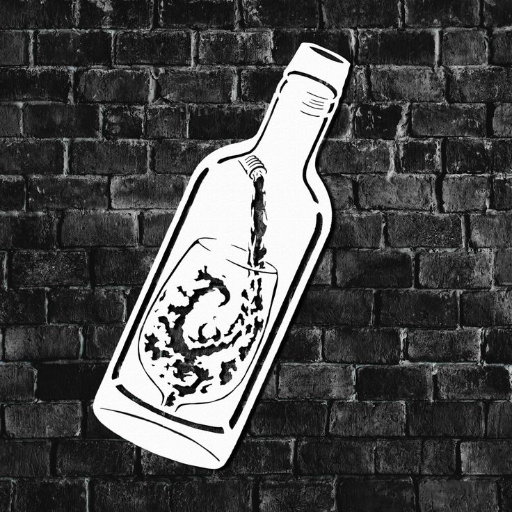 a black and white photo of a bottle on a brick wall