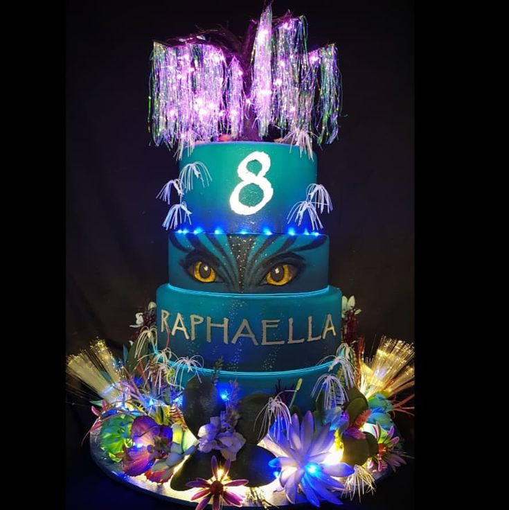 a three tiered cake with lights and decorations on the top is decorated in blue