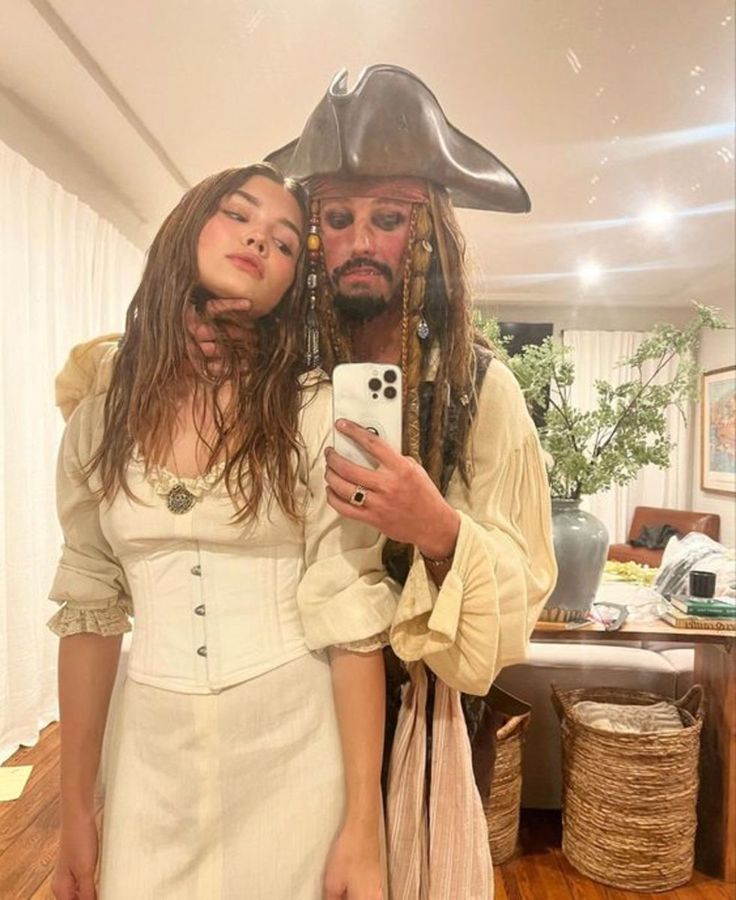 a man in a pirate costume taking a selfie with a woman