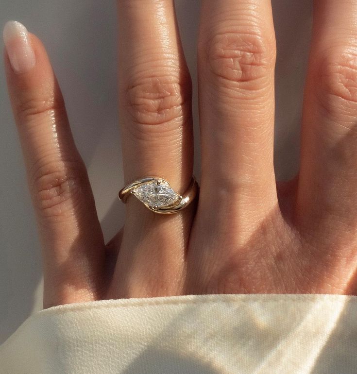 a woman's hand with a diamond ring on it