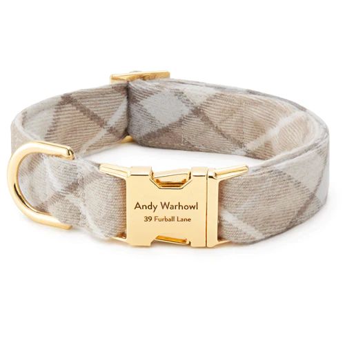 a dog collar with a gold buckle on the front and side, in beige plaid fabric