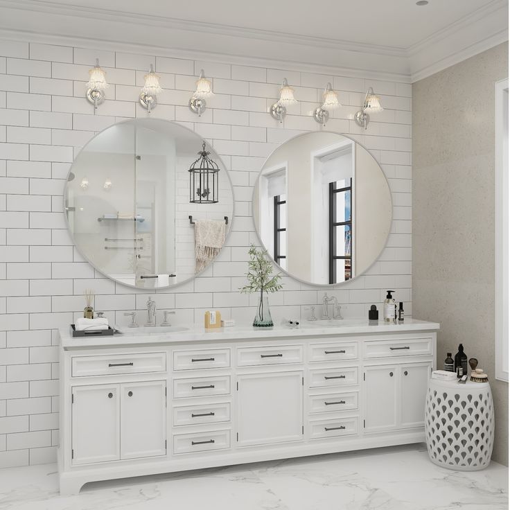 a white bathroom with two mirrors on the wall and double sinks in front of them