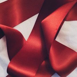 red satin ribbon on white fabric