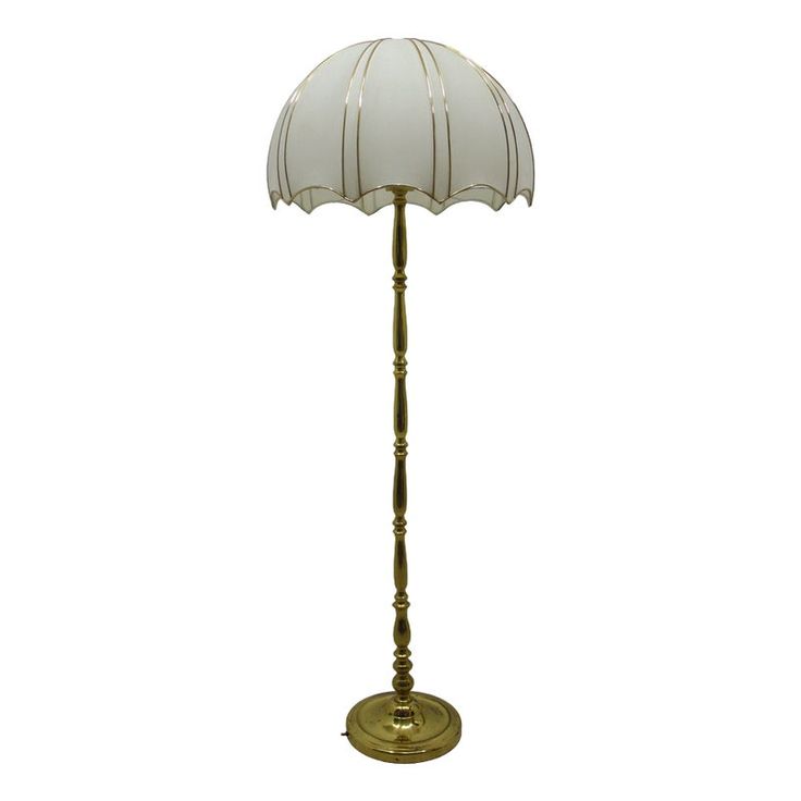 an antique brass floor lamp with a white shade on the top and bottom part of it