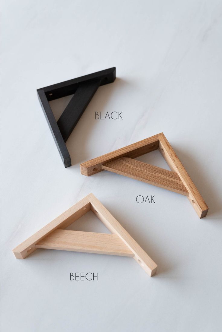 three pieces of wood sitting next to each other on a white surface with the words black, oak, and beech