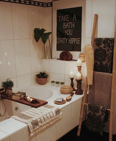 a bathroom with a bathtub, towel rack and candles on the counter next to it