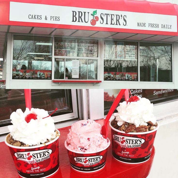 three ice cream sundaes sitting on top of a red table in front of a store