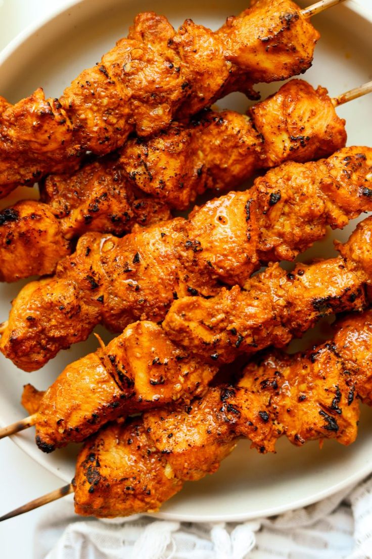 grilled chicken skewers on a white plate