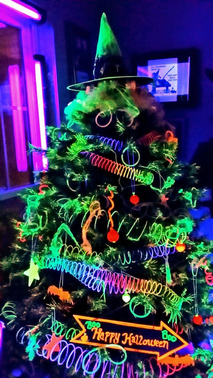 a lit up christmas tree in the middle of a room with many decorations on it