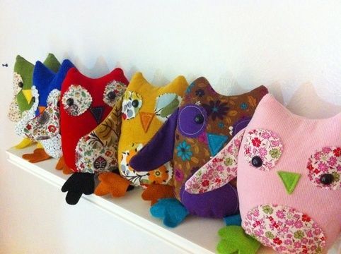 a row of stuffed owls sitting on top of a white shelf