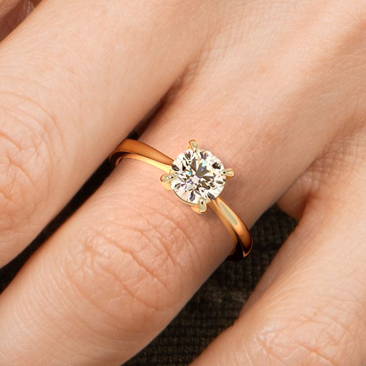 a woman's hand with a diamond ring on top of her finger and an engagement band