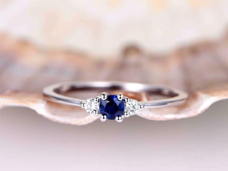 a blue sapphire and diamond ring sitting on top of a shell