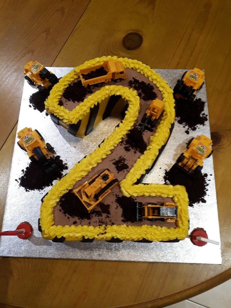 the birthday cake is made to look like a number two with construction vehicles on it