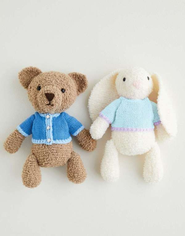 two stuffed animals sitting next to each other on a white surface with one holding the other's hand