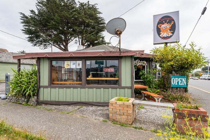 a small green building with a sign on it