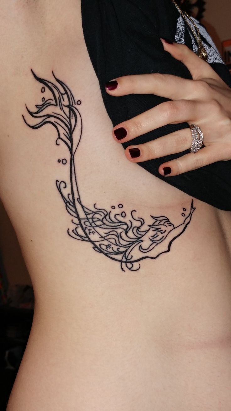 a woman's stomach with a black and white tattoo design on the side of her body