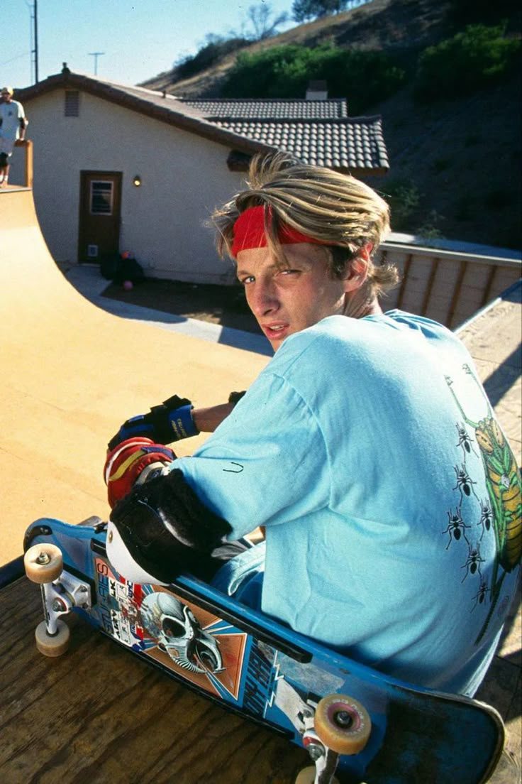 a woman sitting on top of a skateboard ramp