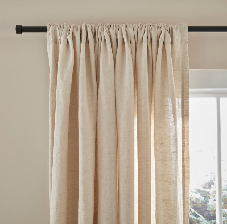 an open window with curtains hanging on the side and a curtain rod attached to it