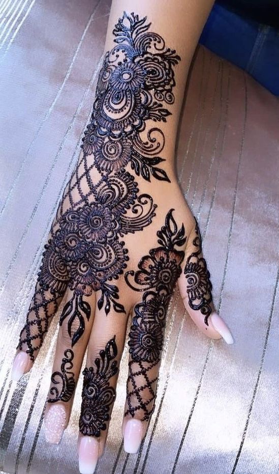 a woman's hand with henna tattoos on it