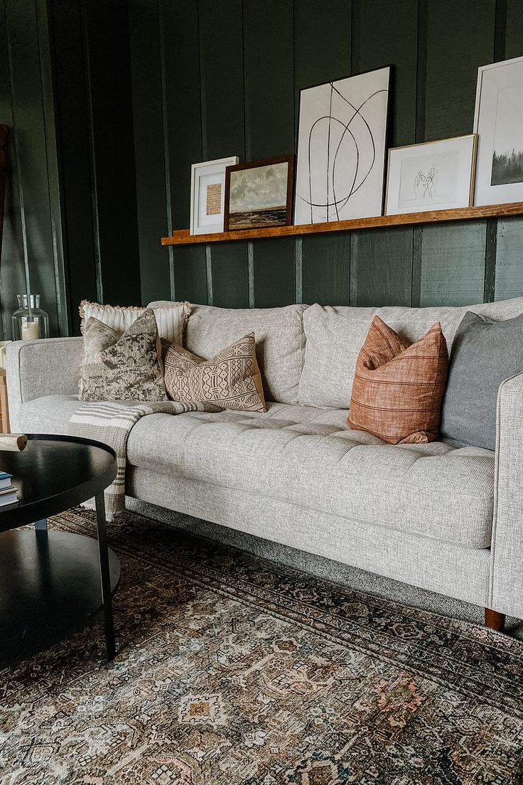 a living room filled with lots of furniture and pillows on top of a rug next to a coffee table