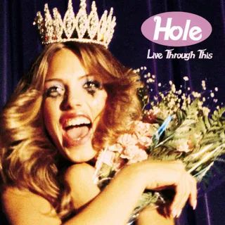 a woman wearing a tiara and holding flowers in front of a blue curtain with the words hole live through this