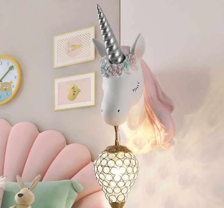 a lamp that is sitting on top of a table in front of a unicorn head