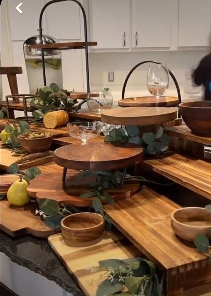 a kitchen counter topped with lots of wooden cutting boards and bowls filled with fruit on top of it