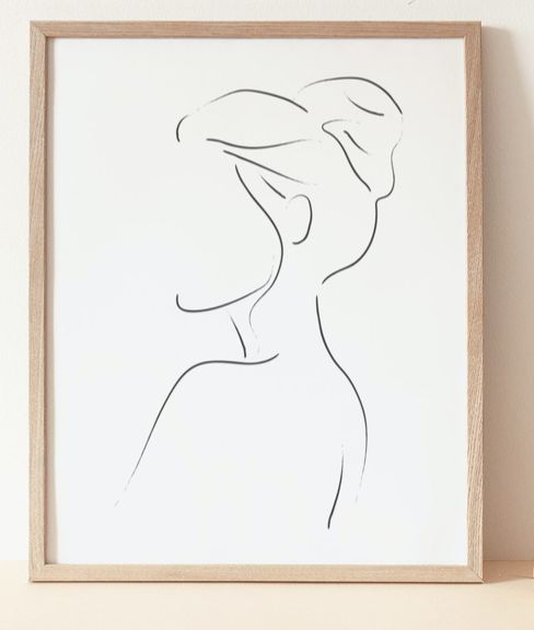 a line drawing of a woman's profile on a white background in a wooden frame