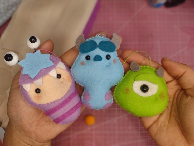 three small stuffed animals are in the palm of someone's hand with eyeballs on them