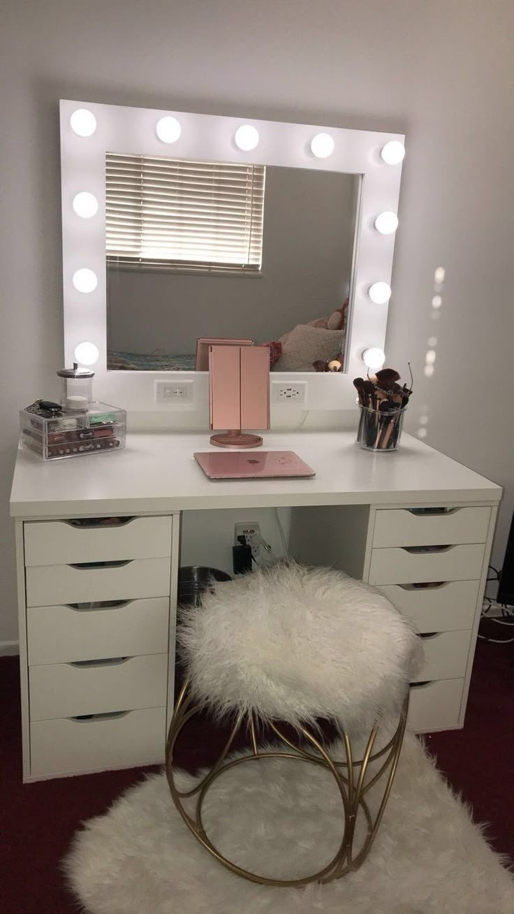 a white vanity with lights and a stool