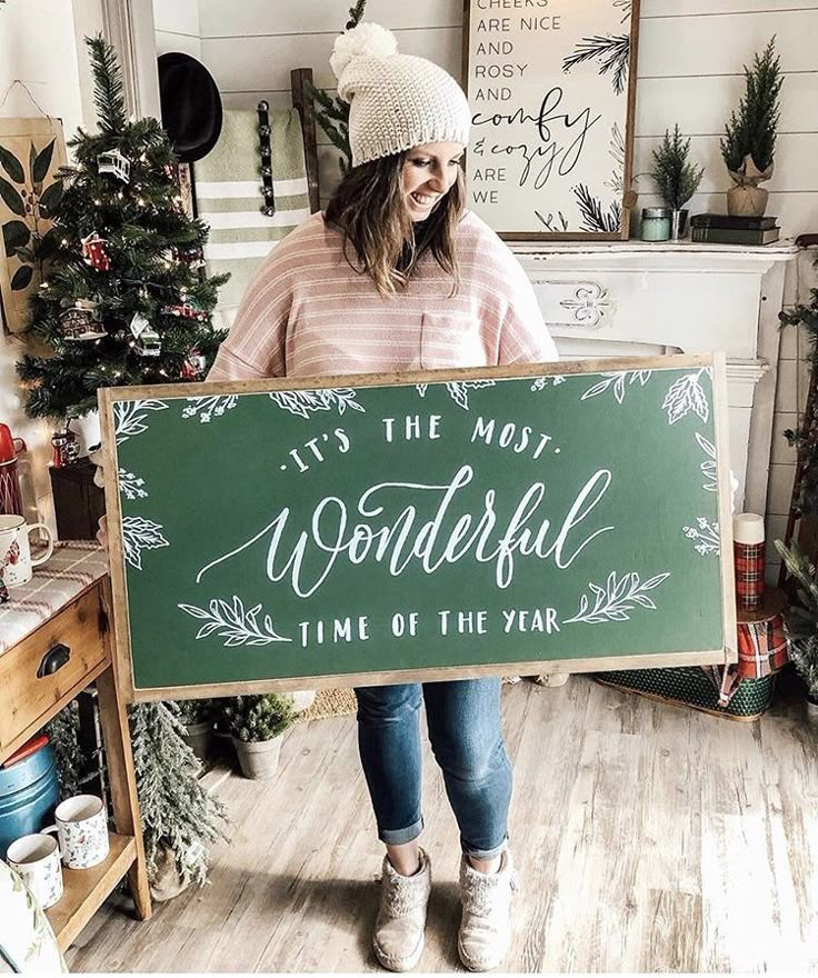 a woman holding a sign that says it's the most wonderful time of the year