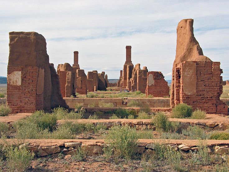 an old ruin in the middle of nowhere with no people or animals around it and grass growing on the ground