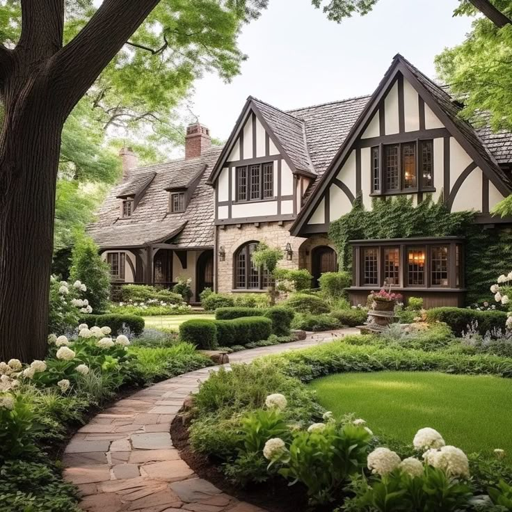 a large house surrounded by lush green trees and bushes with white flowers on the front