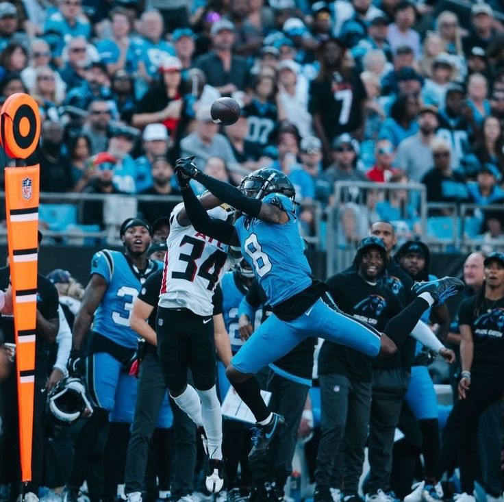 a football player jumping up into the air to catch a ball