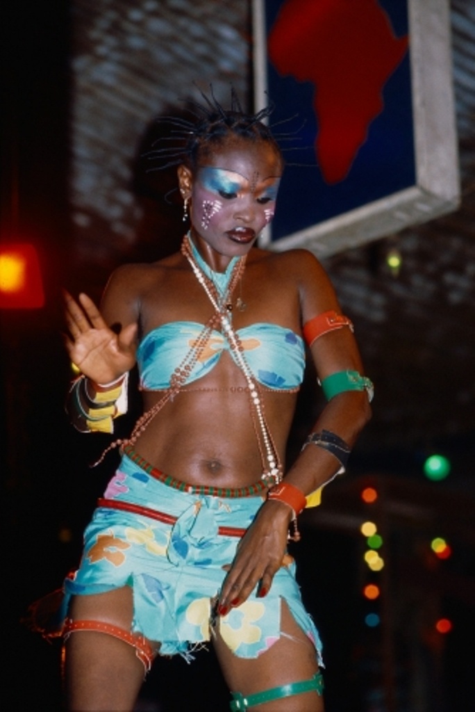 a woman with painted face and body standing in front of a basketball hoop