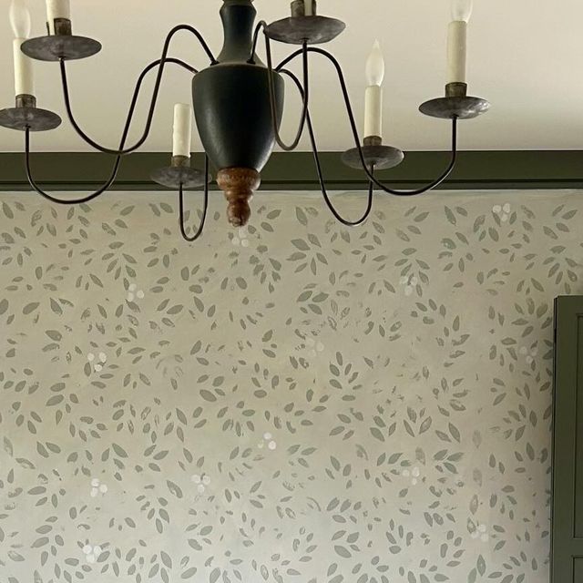 a chandelier hanging from the ceiling in a room with white walls and green cupboards