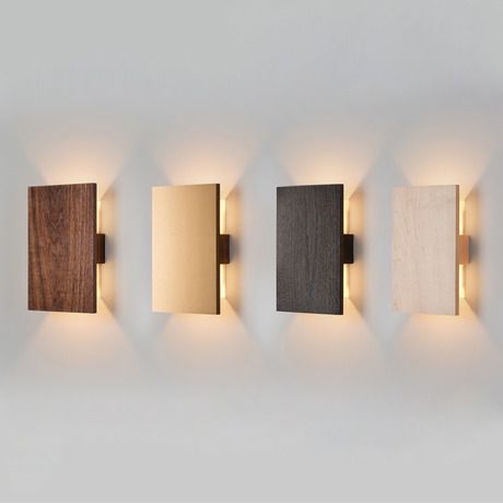 four different types of wall lights mounted on the side of a wall in a room