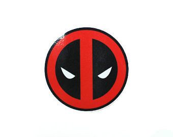 a deadpool sticker on the side of a white wall with red and black eyes