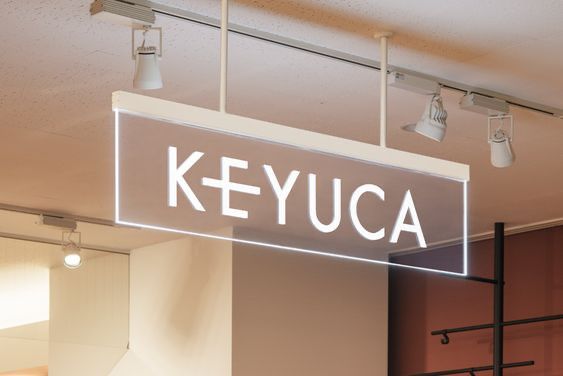 a sign that reads keyua hanging from the ceiling in front of some lamps and lights