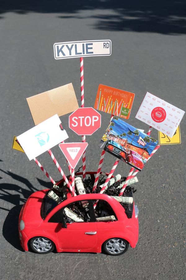 a red toy car with various street signs on it's roof sitting in the middle of an intersection