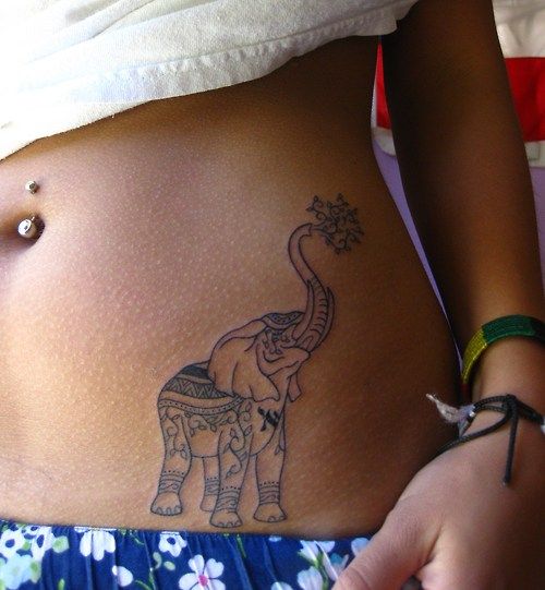 a woman's stomach with an elephant tattoo on it