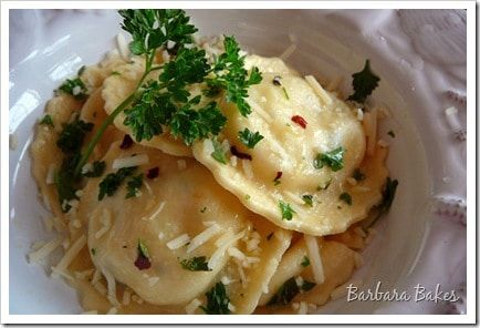 a white plate topped with ravioli and parsley