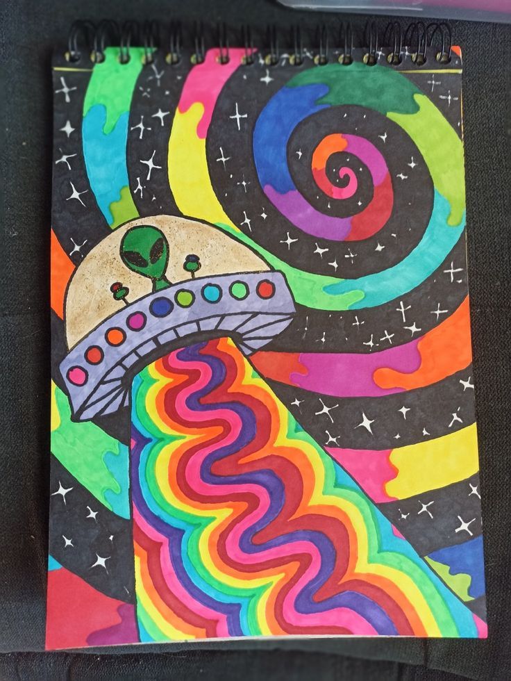 a spiral notebook with an image of a space ship in the sky and stars on it