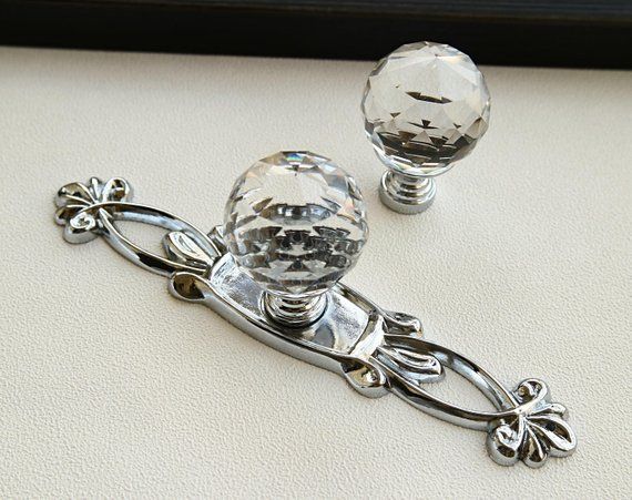 two glass door knobs on a white surface