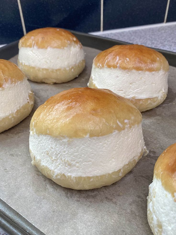 several round breads sitting on top of a baking pan