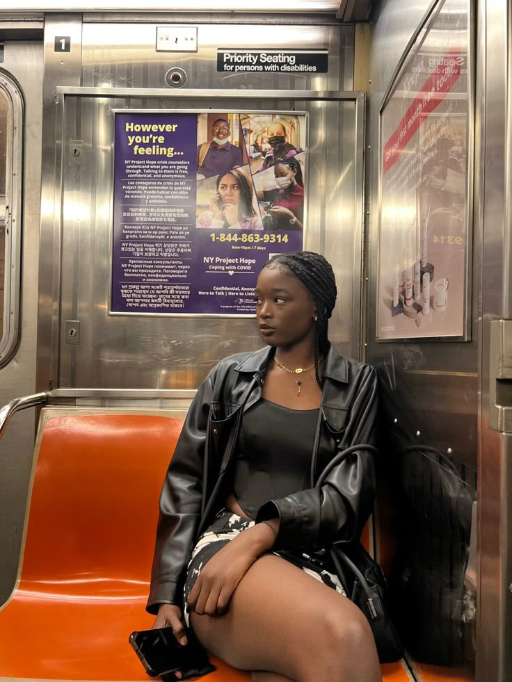 a woman sitting on an orange seat in a subway