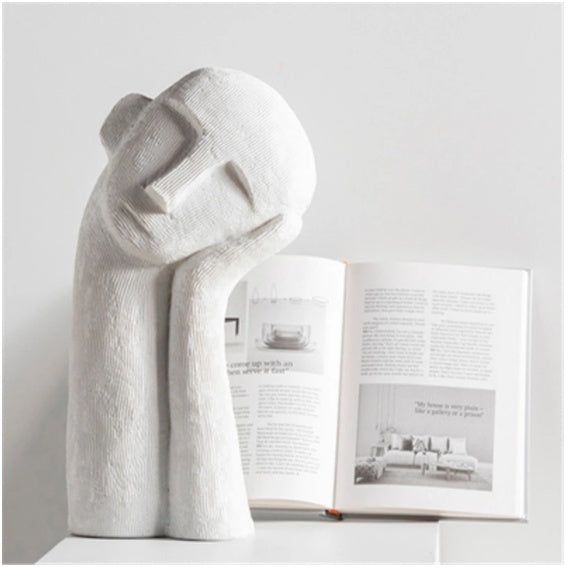 a white towel wrapped around a book on top of a shelf next to an open book