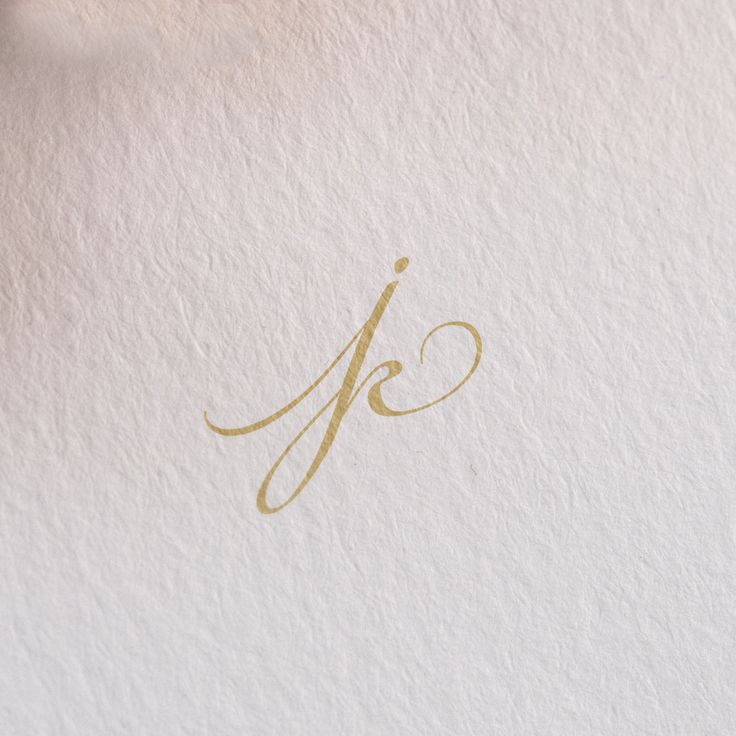 the letter j is written in gold on white paper