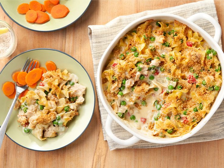 a casserole dish with chicken, peas and carrots next to a plate of food