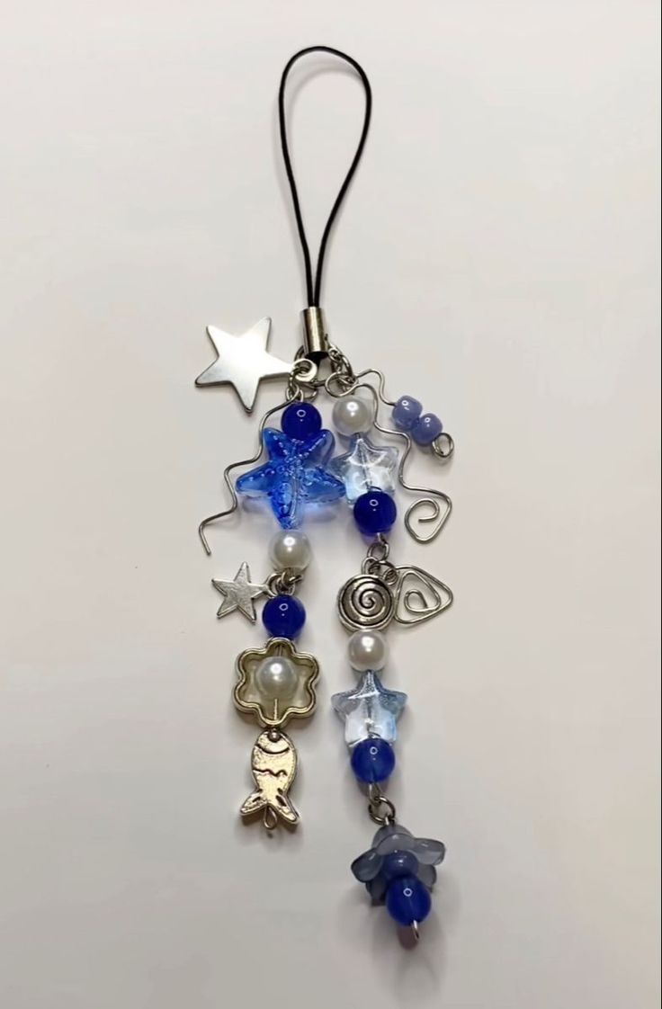 a blue and white beaded necklace hanging from a hook on a string with star charms